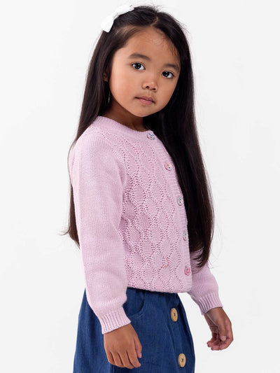 Young girl with long dark hair wearing a 100% cotton, honeycomb woven knit Audrina Violet Cardigan from Knitwear and blue skirt, standing against a white background.