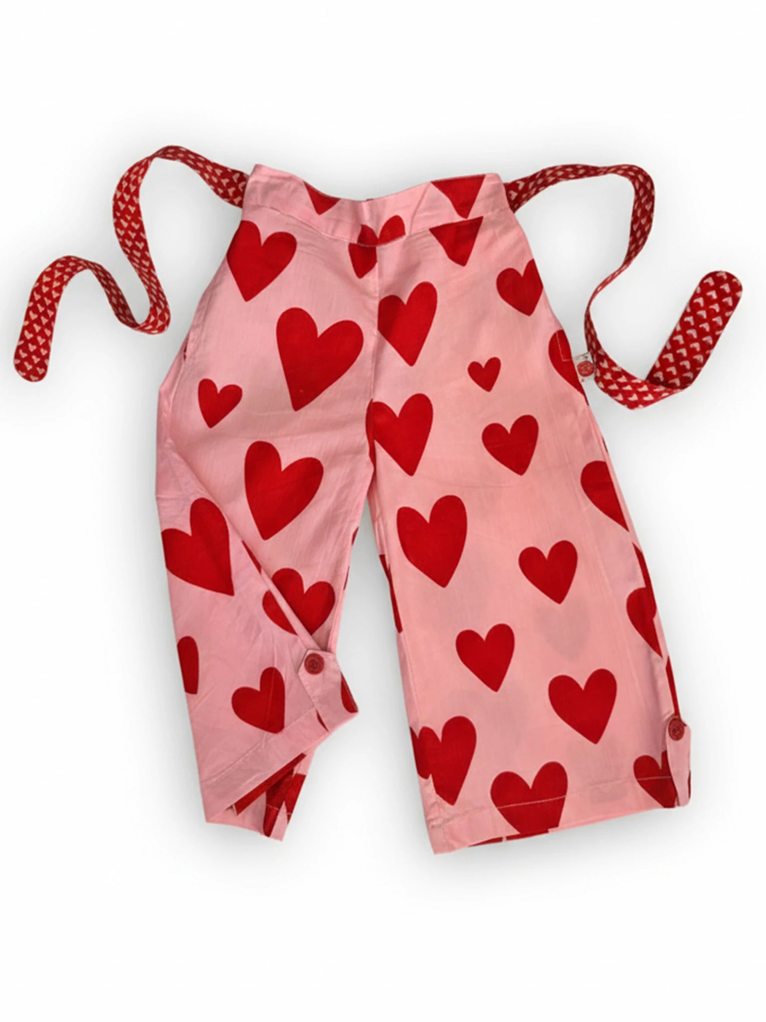 Big Hearts’ Big Heart Wide-Leg Pants feature hand-printed pink fabric with red heart prints, an elastic waist, and red-and-white patterned ties, shown flat on a white background.