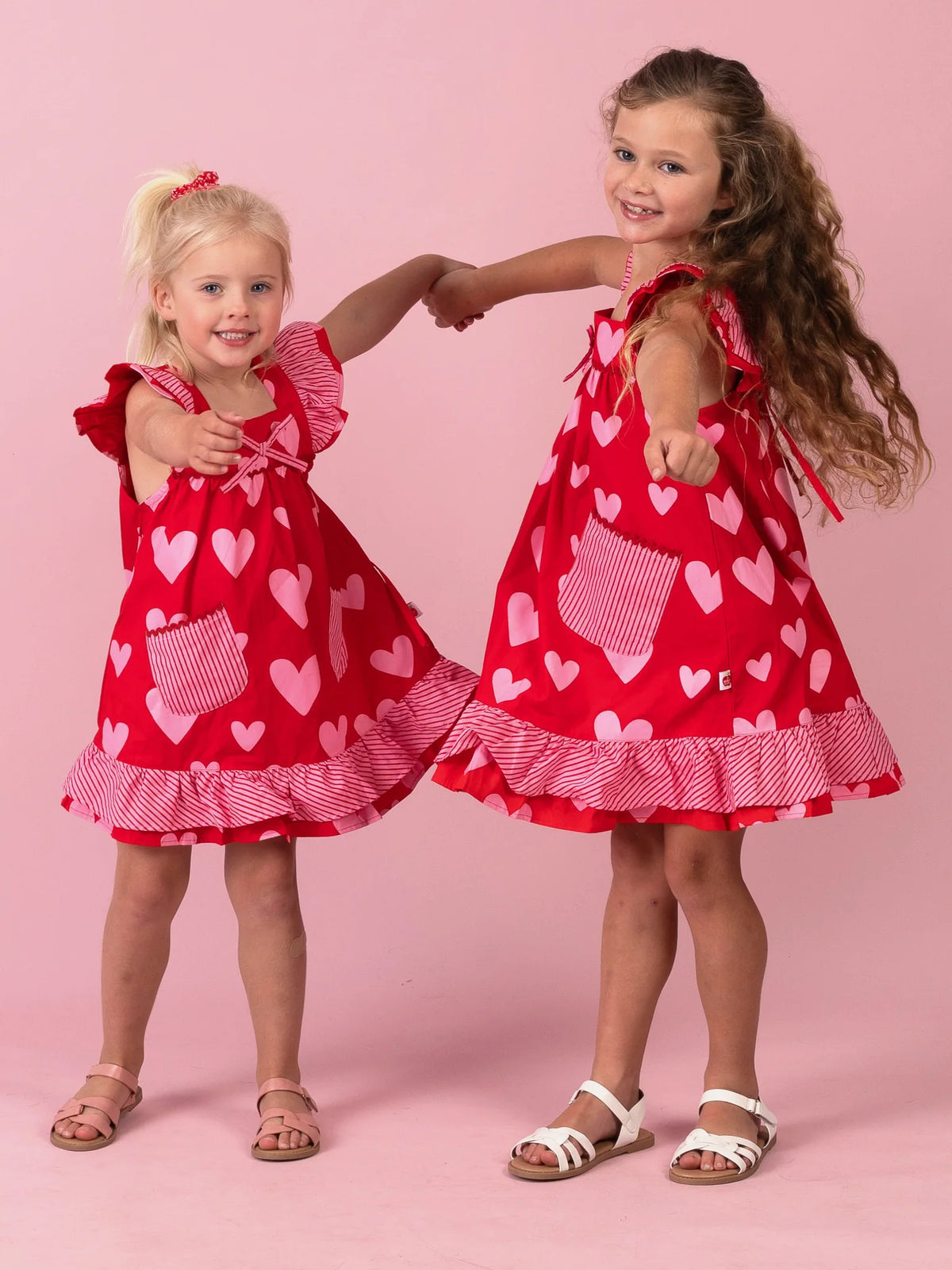 Girl in the Big Red Heart Holly dress with gingham pockets