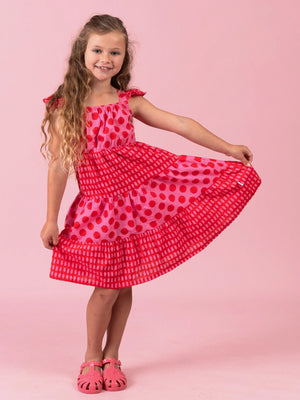 Girl showing the tiered skirt of the red and pink Jaipur Holiday dress