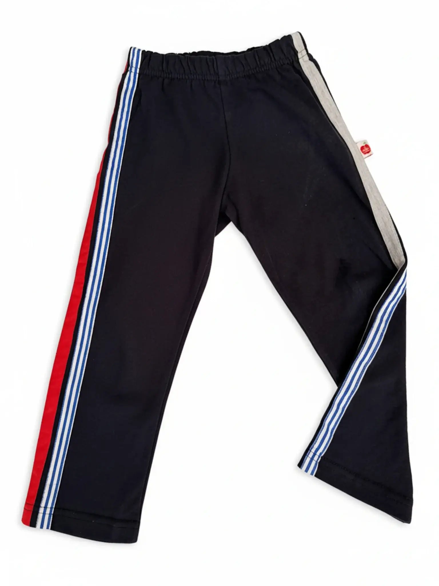 Essentials Navy Jersey 2 Stripe Pants for kids, featuring blue and white stripes, a red stripe on one leg, and a gray panel on the other. Ideal for sportswear. Shown on a white background.
