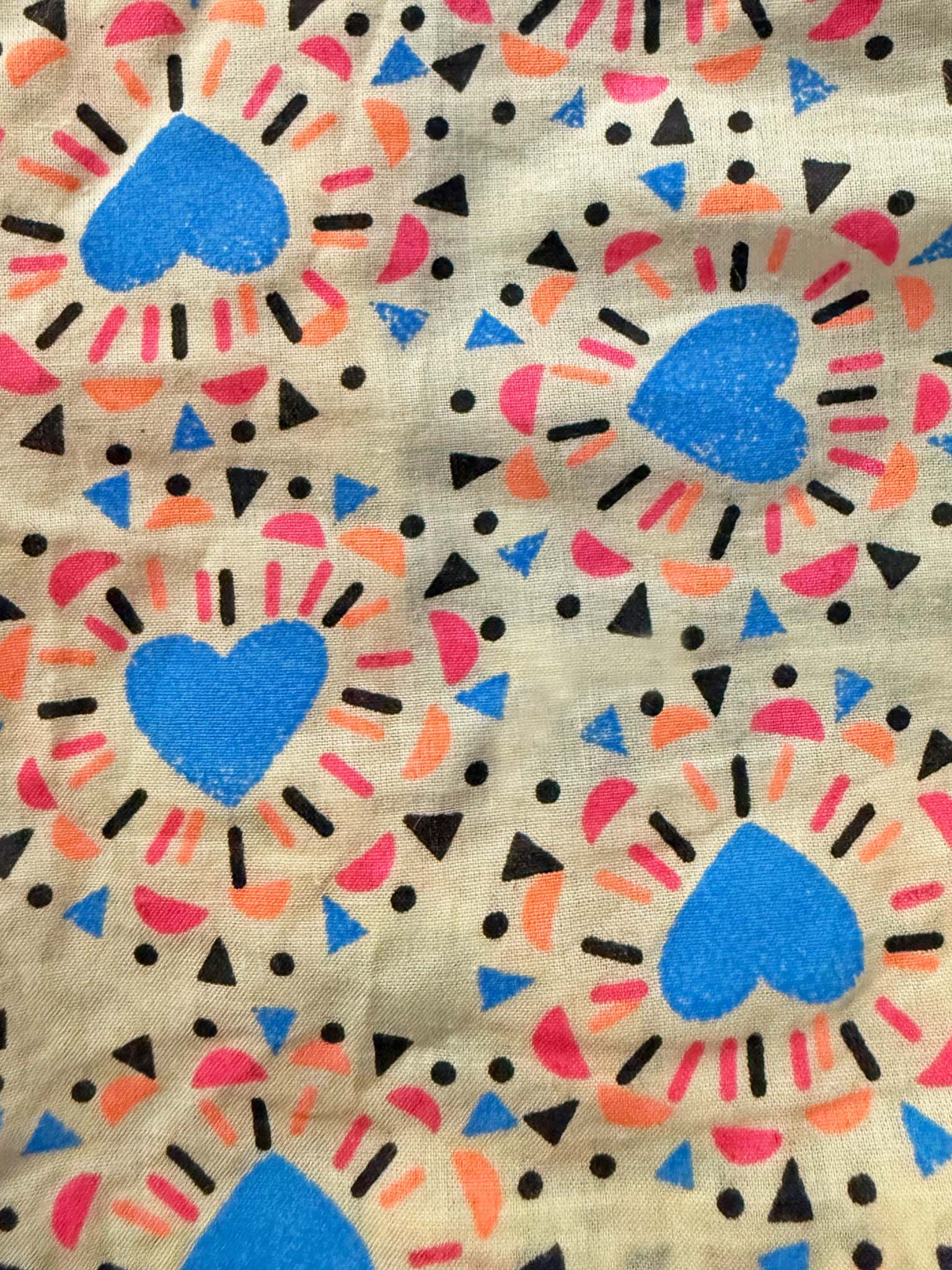 The Starburst Ruffle Shorts by Starburst are hand screen printed and ethically made, with blue hearts and orange, pink, and black geometric shapes on a light background.