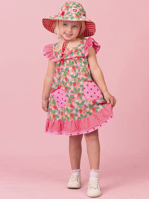 Girl holding out the ruffle hem of her Strawberry Holly dress
