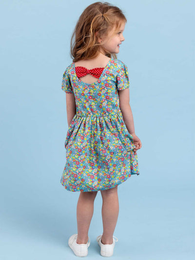 The back of a little girl in a Sweetie Bows Minifloral Dress by New Minifloral with pockets.