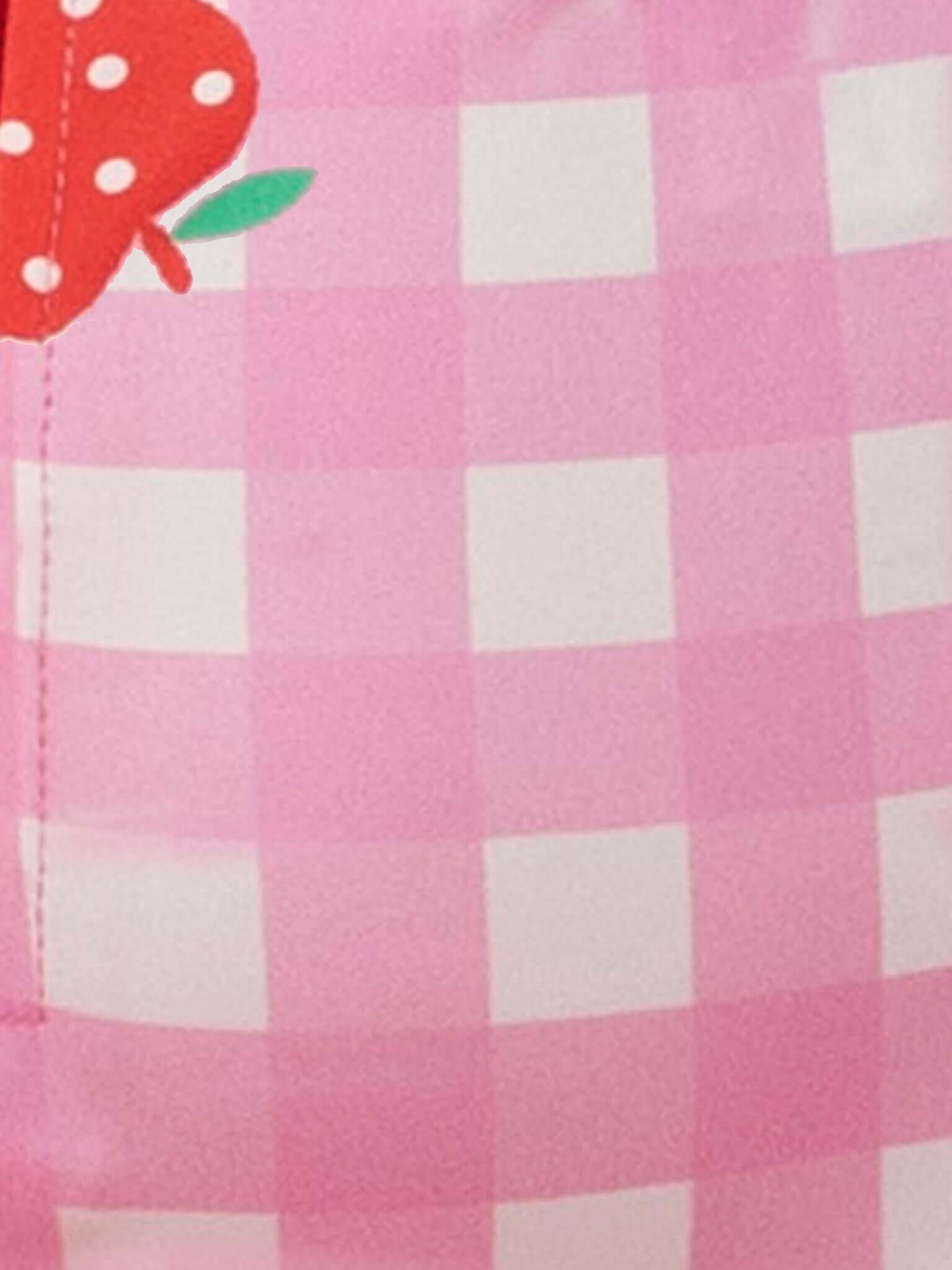 Close-up of the Pink Gingham SPF 50 Gingham Long Sleeve Swimsuit, highlighting pink and white checks with a partial red strawberry and green leaf detail in the upper left corner.