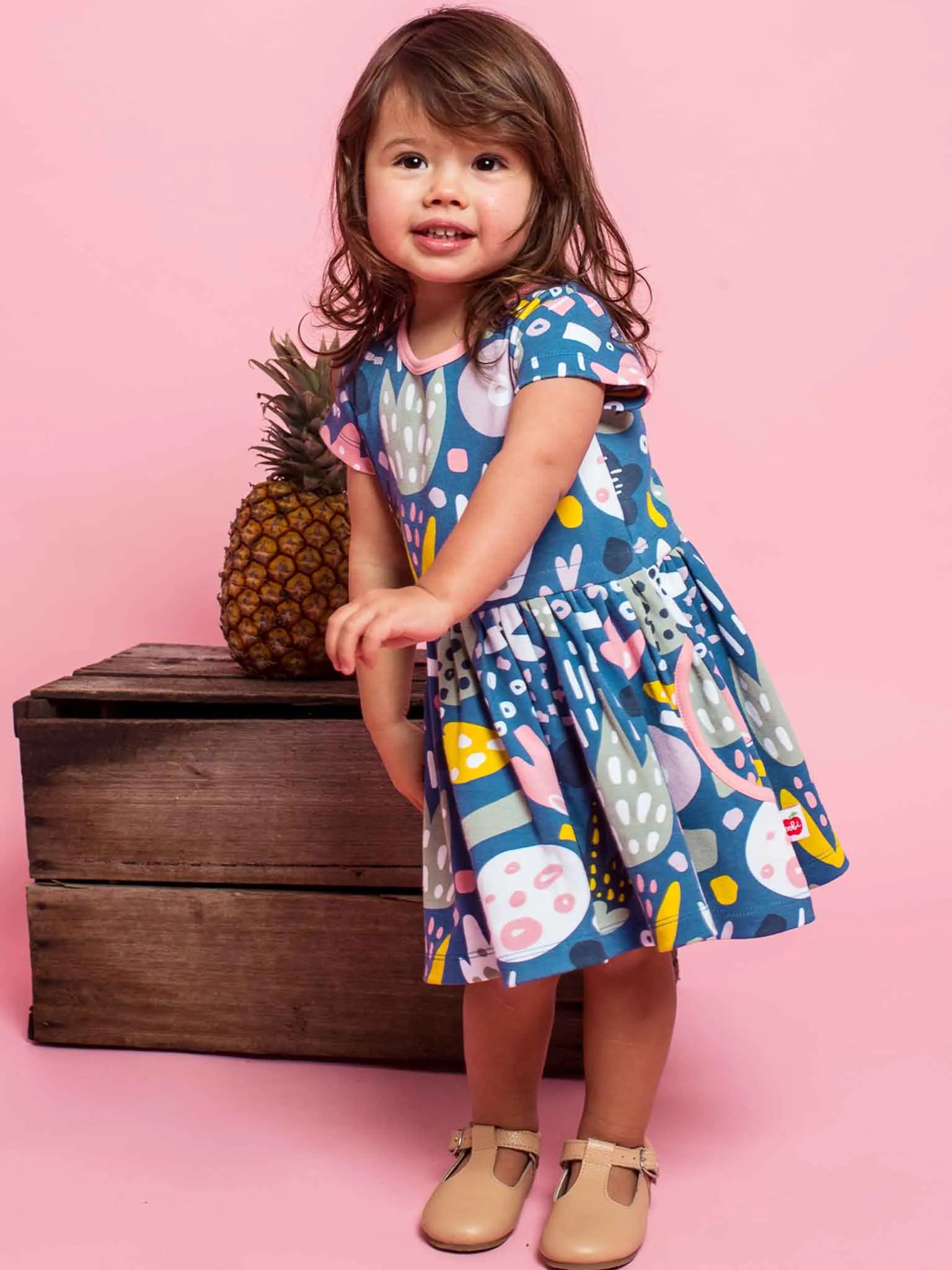 Smiling girl wearing a navy blue jungle print dress
