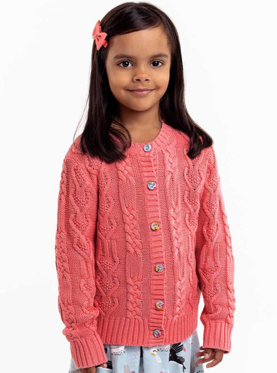 A little girl wearing a Willow Geranium Pink Cotton Cardigan by Knitwear with fabric covered buttons and cotton cable knit skirt.