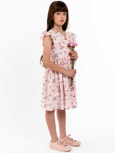A girl in a Vintage Pink Floral Madison Dress by Pink Flowers holding a rose.