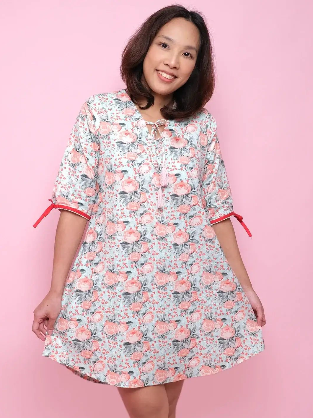 Woman wearing a floral dress with pink background