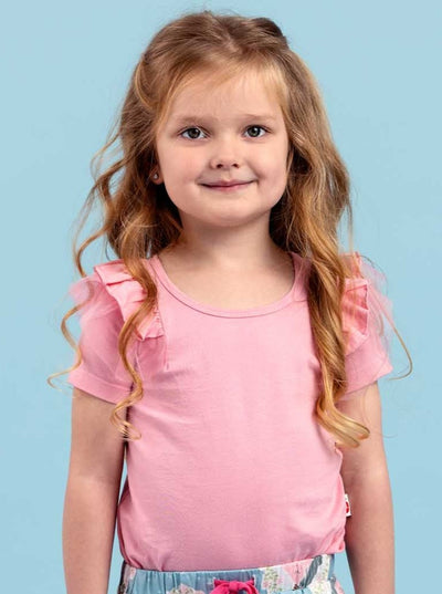 An Aussie child in an Essentials Sweetpea Light Pink Tee with ruffle sleeves.