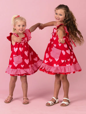 Girl in the Big Red Heart Holly dress with gingham pockets