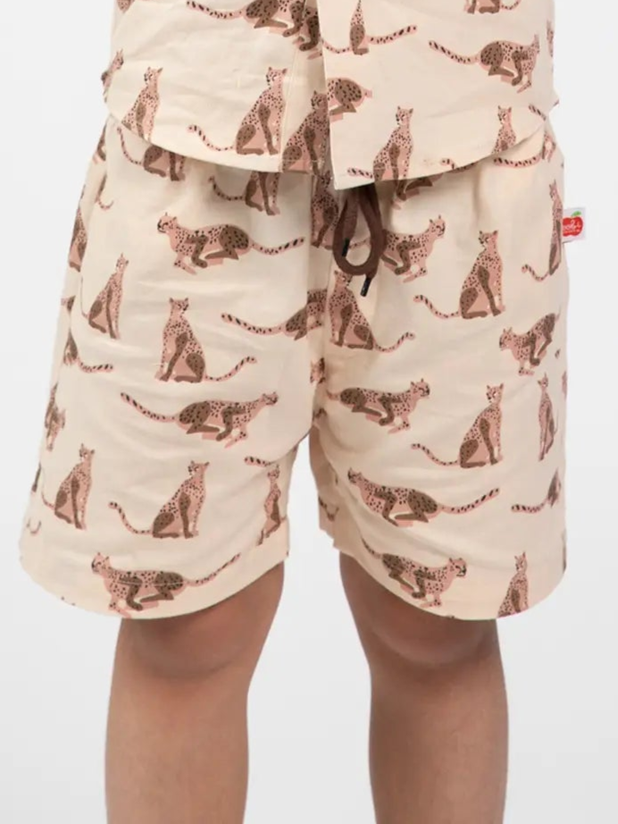 Beige shorts with leopard pattern worn by a person on a white background