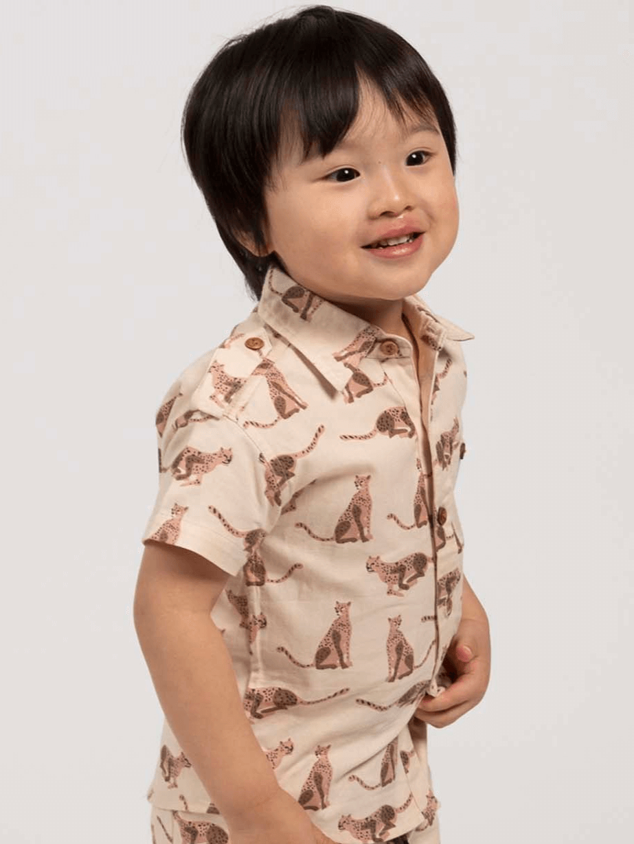 Child wearing a beige, leopard animal-patterned collared shirt 