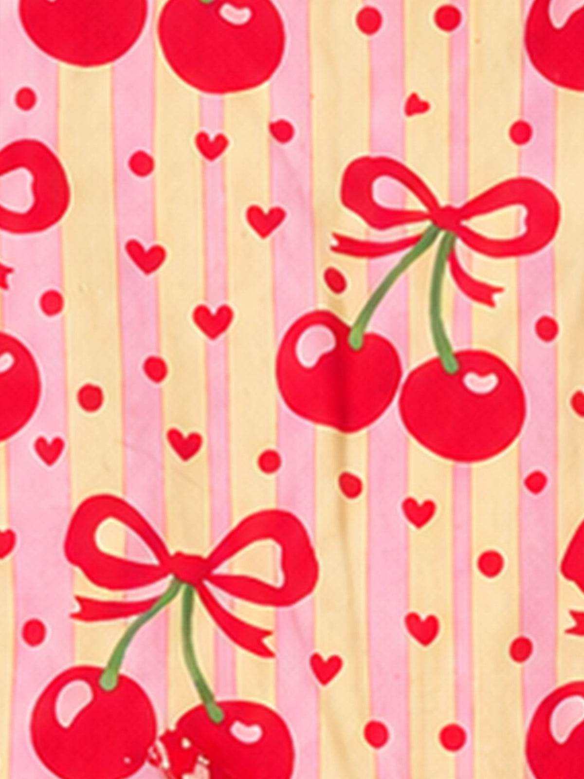 A close-up of a fabric pattern featuring red cherries with bows, red hearts, and red dots on alternating pink and pale yellow vertical stripes.