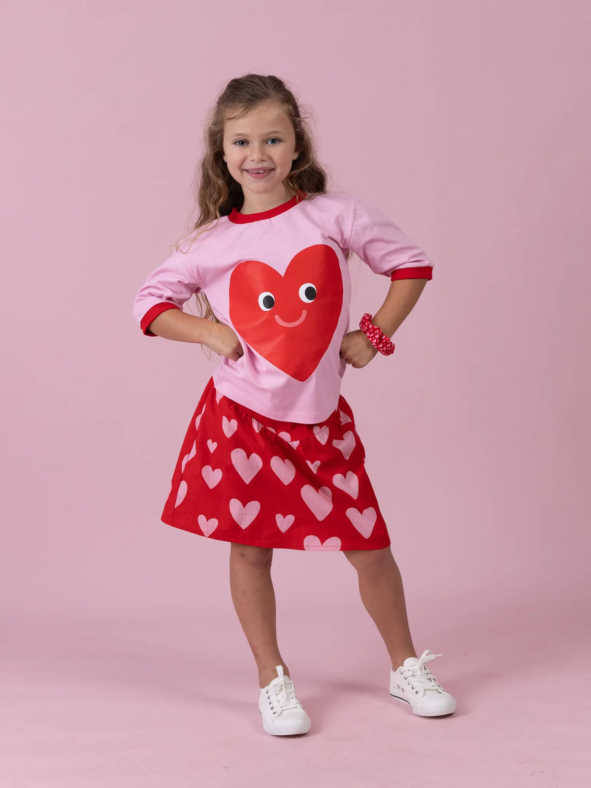 Smiling girl in the Happy Heart tee on pink with the Big Red Heart skirt