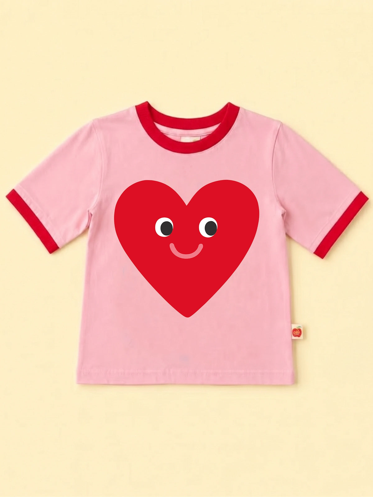 Pink tee with red binding with a big red smiling heart face design