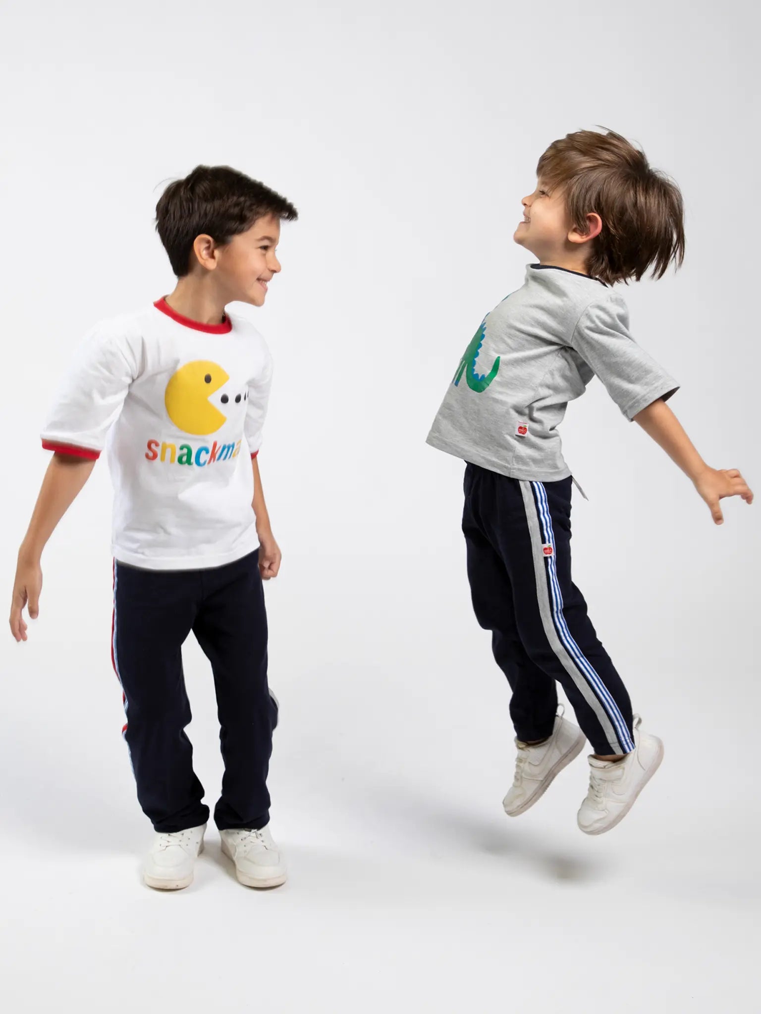 Two children wearing colorful clothing with visible branding on a white background