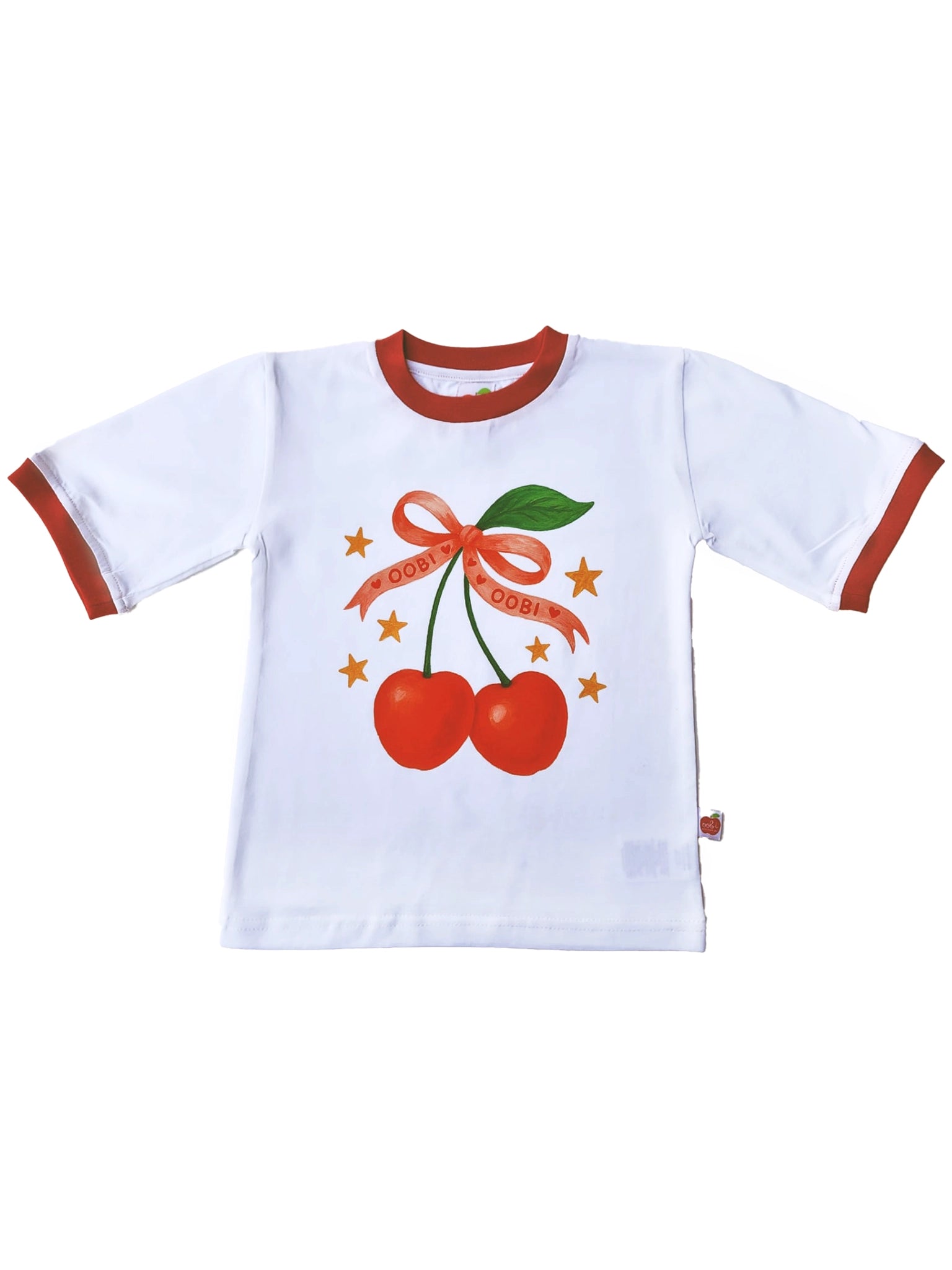 Essentials' White Cherry Tee with Red Binding showcases a hand-printed Cherry Bow design of two cherries with a ribbon and orange stars, adding a unique touch. Made from oversized cotton in Australia.