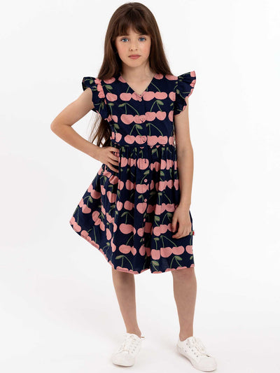 A young girl wearing a Navy Cherry Madison Dress with pink flowers on it.