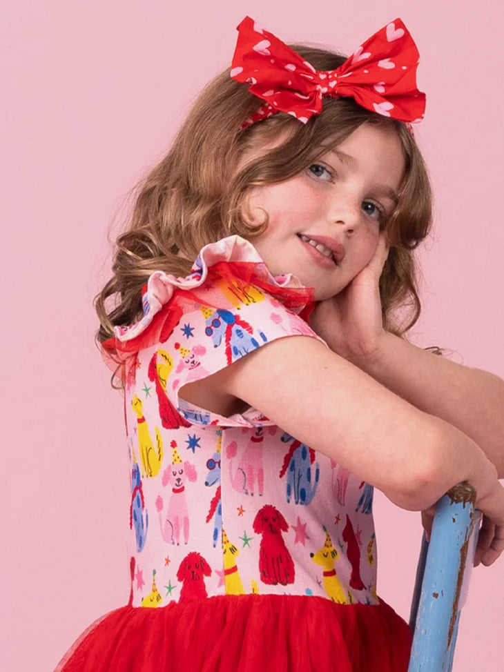 Girl wearing the Pink & Red Mini Hearts bow headband, an oversized red bow with tiny hearts