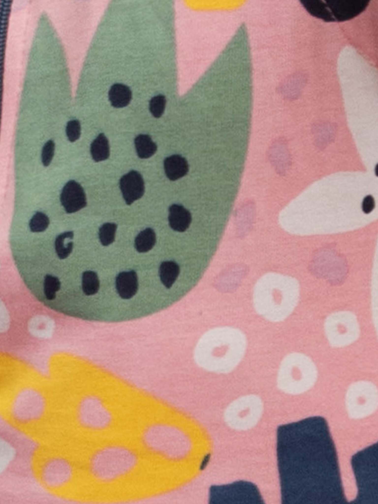 The Tala Jungle Jersey Playsuit by Wild Jungle is made from 100% cotton and features a vibrant pink jungle print with green, yellow, and white shapes and black dots in an abstract pattern.