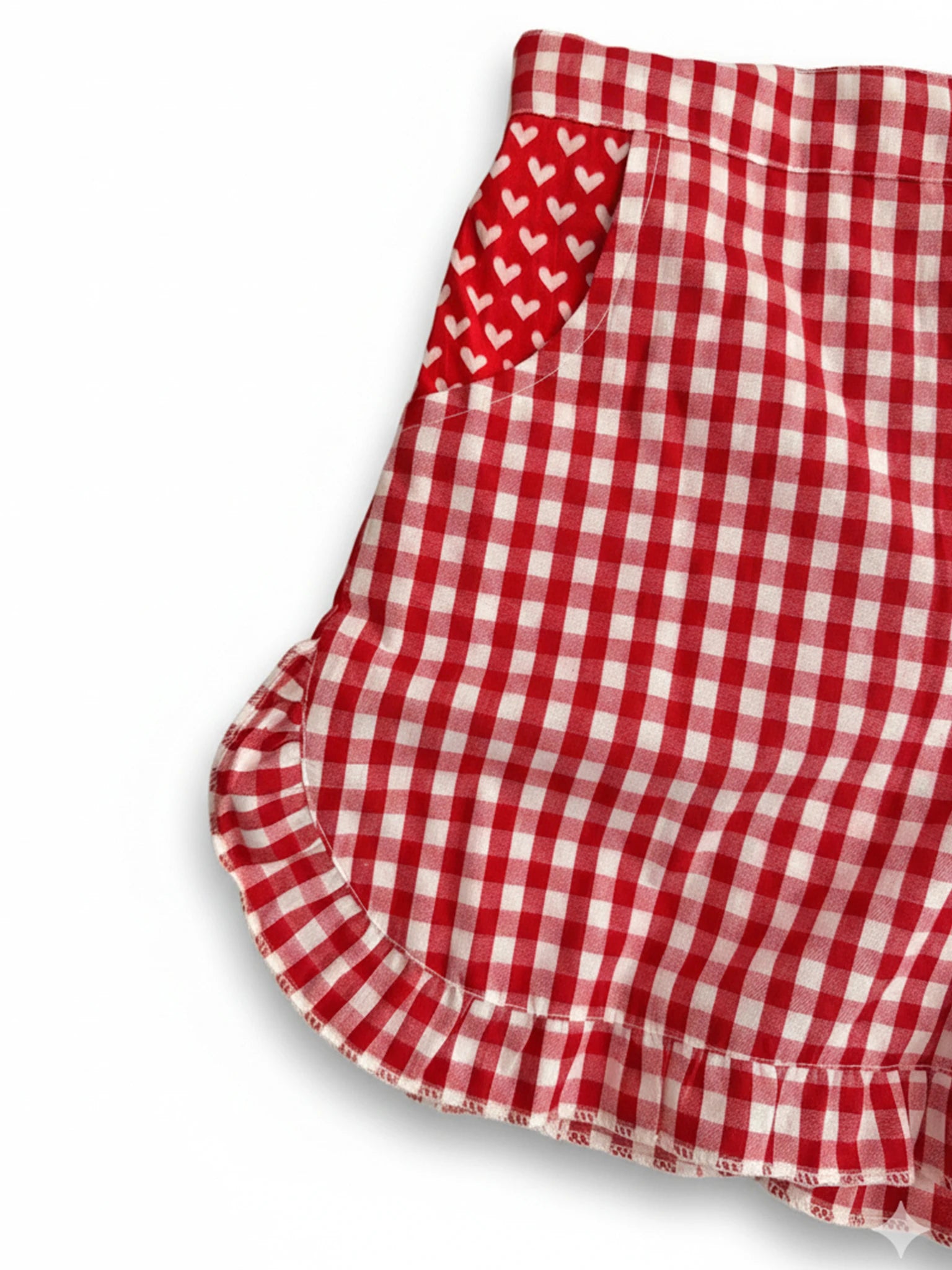 Red and white gingham shorts with a ruffled hem and side pocket featuring hand-printed red hearts—perfect to pair with the Essentials Red and Pink Hearts Headband.