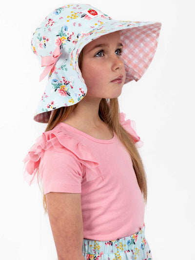 A little girl wearing a Vintage Blue Floral Chloe Hat and floral skirt by the brand Blue Floral.