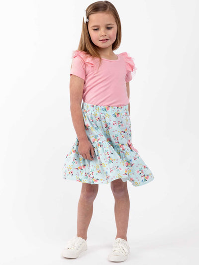 A little girl wearing a pink shirt and a Vintage Blue Floral Ruffle Skirt by Blue Floral with an elastic waist.