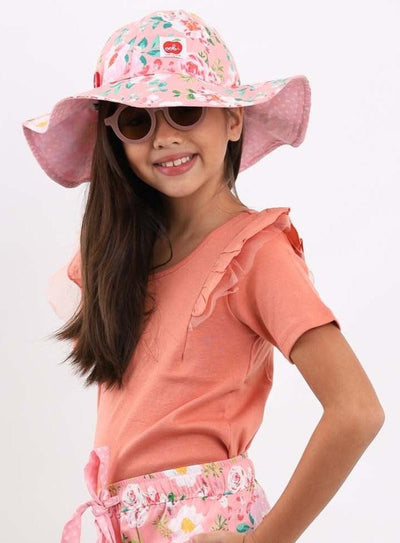 A little girl wearing a Watercolour Margot Pink Watercolour Hat with adjustable straps.