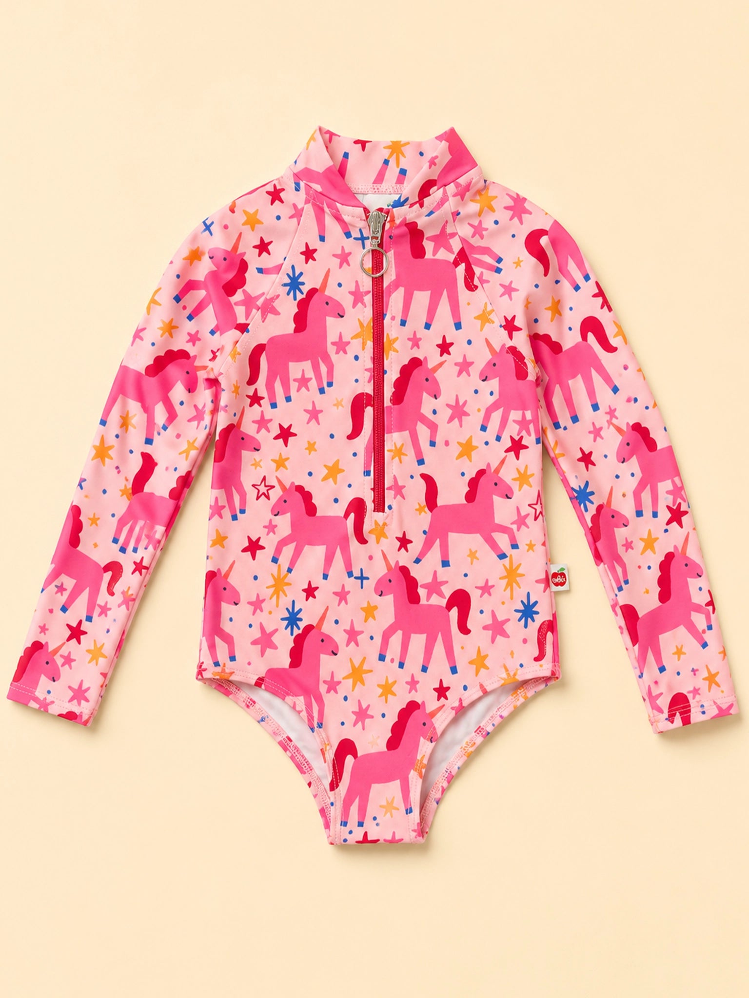 A pink long-sleeve baby bodysuit with a half-zip collar, featuring an all-over print of pink unicorns and colorful stars, laid flat on a light beige background.