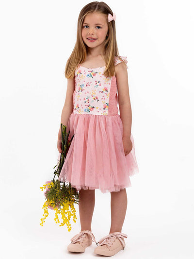 A little girl in a Vintage Pink Floral Belle Tutu Dress by Pink Flowers twirling with flowers.