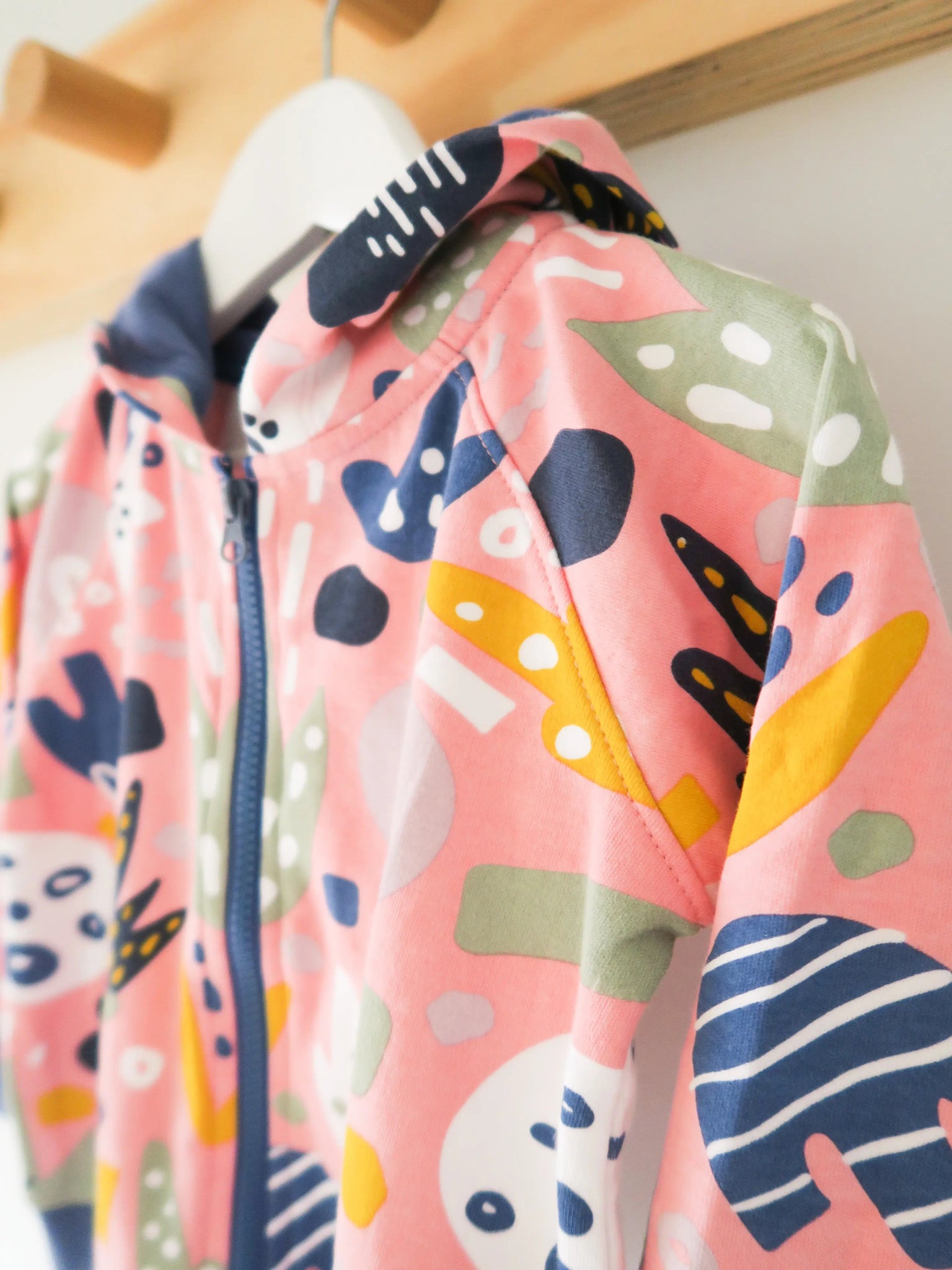 Children's jacket with colorful abstract patterns on a wooden surface